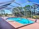 Inviting screened-in pool area with a sparkling pool, surrounded by lush landscaping and ample deck space at 1402 Bluewater Dr, Sun City Center, FL 33573