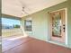 View of the covered front porch and front door of the home showing architecture and ceiling fan at 1402 Bluewater Dr, Sun City Center, FL 33573