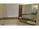 Bathroom featuring a tub, large mirror, and tiled vanity at 1803 Longview Ln, Tarpon Springs, FL 34689