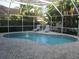 Inviting in-ground pool surrounded by brick pavers and a screened enclosure for outdoor enjoyment at 1803 Longview Ln, Tarpon Springs, FL 34689
