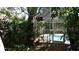 View of a screen-enclosed pool area surrounded by lush greenery, offering a private retreat at 1803 Longview Ln, Tarpon Springs, FL 34689