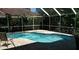 A screened-in pool with a patio and chair, offering a private retreat at 1803 Longview Ln, Tarpon Springs, FL 34689
