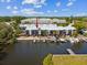 Waterfront condo with boat docks offers scenic views of a waterway, surrounded by lush greenery and clear skies at 200 Meres Blvd # 26, Tarpon Springs, FL 34689