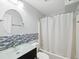 This bathroom features a vanity with a clear glass top and mosaic tile wall at 200 Meres Blvd # 26, Tarpon Springs, FL 34689