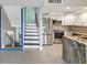 Modern kitchen with stainless steel appliances, granite counters, and adjacent staircase at 200 Meres Blvd # 26, Tarpon Springs, FL 34689