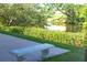 Picturesque backyard featuring a stone bench overlooking a tranquil pond surrounded by vibrant greenery at 208 Villa Dr # 208, Osprey, FL 34229