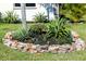 Manicured front yard with decorative rock border and native Florida plants at 208 Villa Dr # 208, Osprey, FL 34229