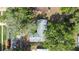 Aerial view of a home with a gray roof, mature trees, and lush greenery in a peaceful neighborhood at 2244 Glenmoor N Rd, Clearwater, FL 33764