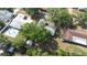 Aerial view featuring a home with a swimming pool, mature trees and lush greenery at 2244 Glenmoor N Rd, Clearwater, FL 33764