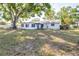 Exterior view of the backyard featuring a patio and large shady tree at 2244 Glenmoor N Rd, Clearwater, FL 33764