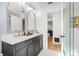 Bright bathroom with dual sinks, gold hardware, and a glass enclosed shower at 2244 Glenmoor N Rd, Clearwater, FL 33764