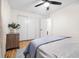 A cozy bedroom featuring a ceiling fan, wood floors, and a closet with sliding doors at 2244 Glenmoor N Rd, Clearwater, FL 33764
