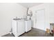 A well-lit laundry room featuring a washer and dryer and a white door at 2244 Glenmoor N Rd, Clearwater, FL 33764