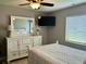 Charming bedroom featuring a comfortable bed, dresser, TV, and natural light at 2250 Sequoia Dr, Clearwater, FL 33763