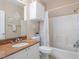 Bathroom featuring a tub, shower, decorative shower curtain, storage cabinet, and granite countertop at 2709 Via Cipriani # 522B, Clearwater, FL 33764