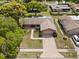 Aerial view of the house shows the driveway, mature trees, and landscaping at 2859 Thistle N Ct, Palm Harbor, FL 34684