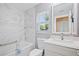 Bright bathroom with marble-look tile, a soaking tub, and a modern vanity with ample storage at 2859 Thistle N Ct, Palm Harbor, FL 34684