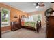 Cozy bedroom with a tropical-themed comforter set, wood furniture, and natural light from the window at 2859 Thistle N Ct, Palm Harbor, FL 34684