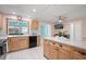 Modern kitchen featuring wood cabinets, black appliances, and an island with counter seating at 2859 Thistle N Ct, Palm Harbor, FL 34684