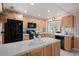 Bright kitchen with wood cabinets, black appliances, and a spacious island with stone countertops at 2859 Thistle N Ct, Palm Harbor, FL 34684
