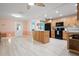 Well-lit kitchen with wood cabinets, modern appliances, and an island, all complementing the light-toned walls at 2859 Thistle N Ct, Palm Harbor, FL 34684