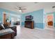 Bright living room with light aqua walls, wood-look tile flooring, and a comfortable seating area at 2859 Thistle N Ct, Palm Harbor, FL 34684