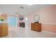 Bright living room featuring wood-look tile, pink walls, and decorative wood cabinets at 2859 Thistle N Ct, Palm Harbor, FL 34684