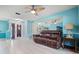 Spacious living room featuring wood-look tile flooring, a leather sofa, and ample natural light at 2859 Thistle N Ct, Palm Harbor, FL 34684