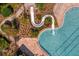 Close up aerial image of a thrilling water slide at the edge of a crystal clear pool at 2935 Winglewood Cir, Lutz, FL 33558