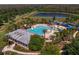 Bird's eye view of a large community pool, waterslide, playground, and scenic water views at 2935 Winglewood Cir, Lutz, FL 33558