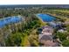 Scenic view of a home near a beautiful lake, surrounded by lush trees and well-manicured lawns at 2935 Winglewood Cir, Lutz, FL 33558