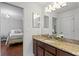 Modern bathroom features granite counters, dark cabinets and a mirror reflecting the bedroom at 2935 Winglewood Cir, Lutz, FL 33558