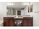 Dual sink vanity area with granite countertops and dark wood cabinets in the main bathroom at 2935 Winglewood Cir, Lutz, FL 33558