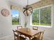 Bright dining area features a wooden table, stylish light fixture, and large windows overlooking the lush outdoors at 2935 Winglewood Cir, Lutz, FL 33558