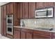 Modern kitchen features stainless steel appliances, granite countertops, and sleek dark wood cabinetry at 2935 Winglewood Cir, Lutz, FL 33558