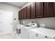 Well-lit laundry room with modern appliances, built-in cabinets, and ample counter space at 2935 Winglewood Cir, Lutz, FL 33558