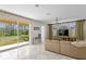 Bright living room features sliding glass doors to backyard, neutral paint, and stylish chandelier for a modern look at 2935 Winglewood Cir, Lutz, FL 33558