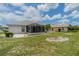 Spacious backyard featuring a screened-in lanai, lush lawn, and decorative landscaping elements at 301 Caloosa Palms Ct, Sun City Center, FL 33573