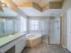 A bright en-suite bathroom featuring a soaking tub, walk-in shower and single vanity at 301 Caloosa Palms Ct, Sun City Center, FL 33573