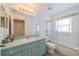 Clean bathroom featuring a vanity with cabinets, a toilet, and a glass-enclosed shower/tub combination at 301 Caloosa Palms Ct, Sun City Center, FL 33573