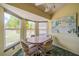 Bright breakfast nook with large windows, a chandelier, and a serene garden painting at 301 Caloosa Palms Ct, Sun City Center, FL 33573