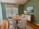 Elegant dining room with wood floors, matching modern furniture, and a large bright window at 301 Caloosa Palms Ct, Sun City Center, FL 33573