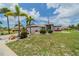 Charming single-Gathering home with a well-manicured lawn, palm trees, and a two-car garage at 301 Caloosa Palms Ct, Sun City Center, FL 33573