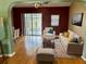Cozy living room featuring hardwood floors, modern furniture, and access to the screened-in lanai at 301 Caloosa Palms Ct, Sun City Center, FL 33573