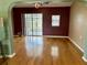 Empty living room features beautiful hardwood floors, modern ceiling fan, and sliding glass doors to lanai at 301 Caloosa Palms Ct, Sun City Center, FL 33573