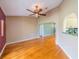 Spacious living room with hardwood floors, a ceiling fan, and an archway leading to the kitchen at 301 Caloosa Palms Ct, Sun City Center, FL 33573