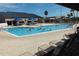 Outdoor pool with plenty of lounge chairs and open umbrellas, perfect for enjoying the sunshine and fresh air at 301 Caloosa Palms Ct, Sun City Center, FL 33573