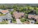 Aerial view of a pink one story home featuring mature trees, landscaping, and a tile roof at 3136 Sandhill Dr, Holiday, FL 34691