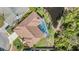 Aerial view of the house with screen enclosed pool, landscaping, and a tile roof at 3136 Sandhill Dr, Holiday, FL 34691