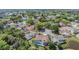 Aerial view of a pink house with mature trees, landscaping, and other homes in the neighborhood at 3136 Sandhill Dr, Holiday, FL 34691
